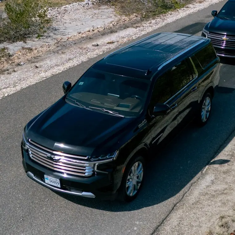 Black Chevrolet Suburban seen from above on a limestone road